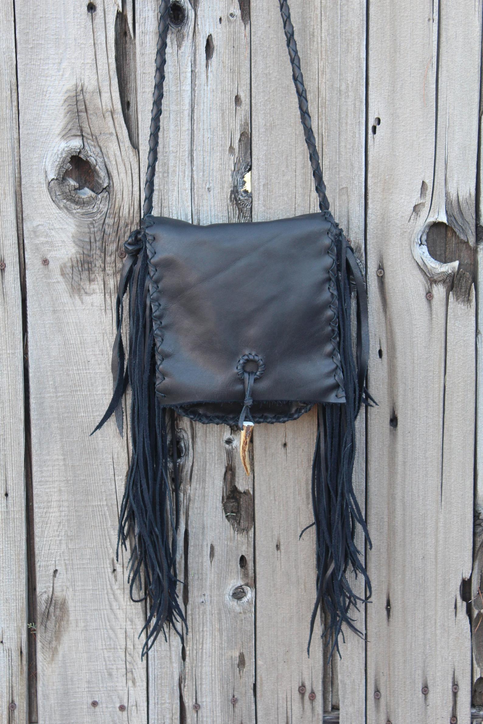 Black leather handbag with fringe and an antler tip closure