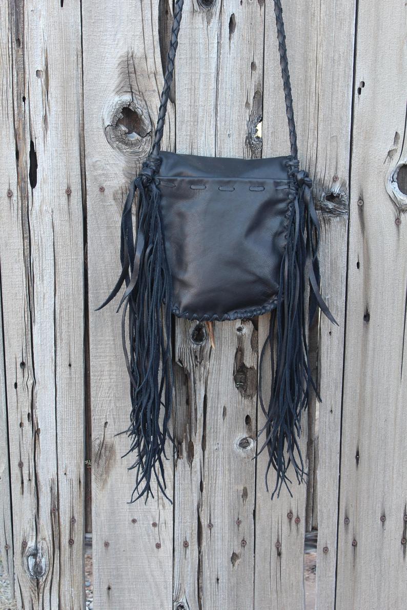 Black leather handbag with fringe and an antler tip closure