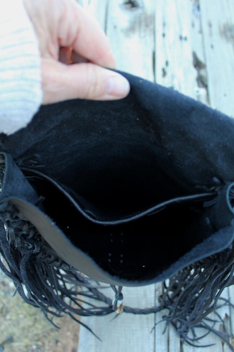 Black leather handbag with fringe and an antler tip closure