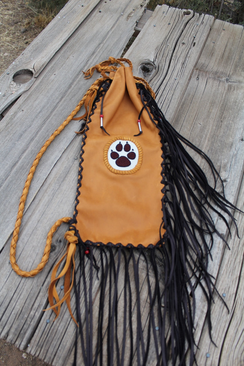 Fringed pipe bag with a beaded wolf paw, chanupa bag