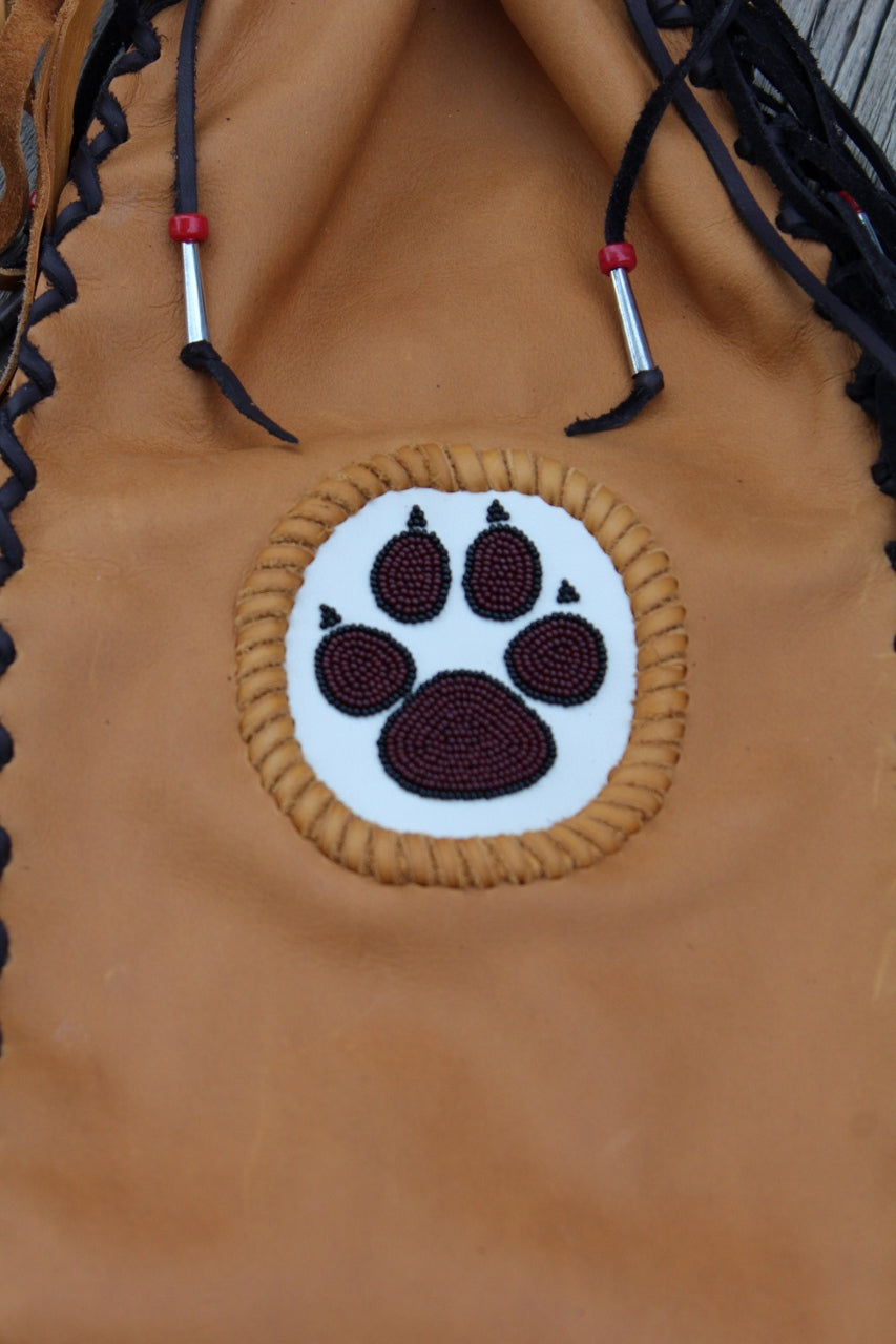 Fringed pipe bag with a beaded wolf paw, chanupa bag