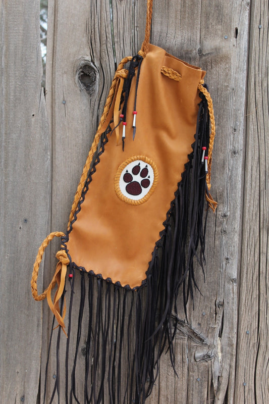 Fringed pipe bag with a beaded wolf paw, chanupa bag