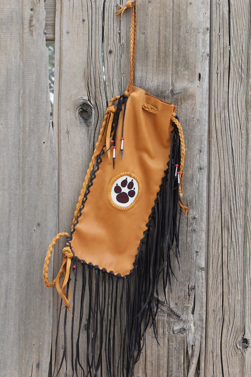 Fringed pipe bag with a beaded wolf paw, chanupa bag