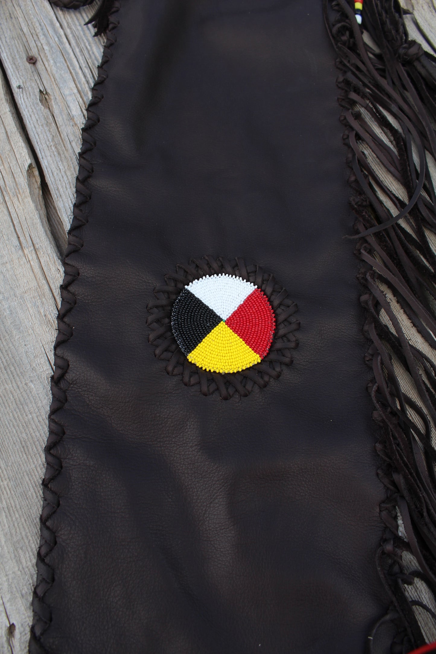 Fringed leather flute bag with beaded medicine wheel